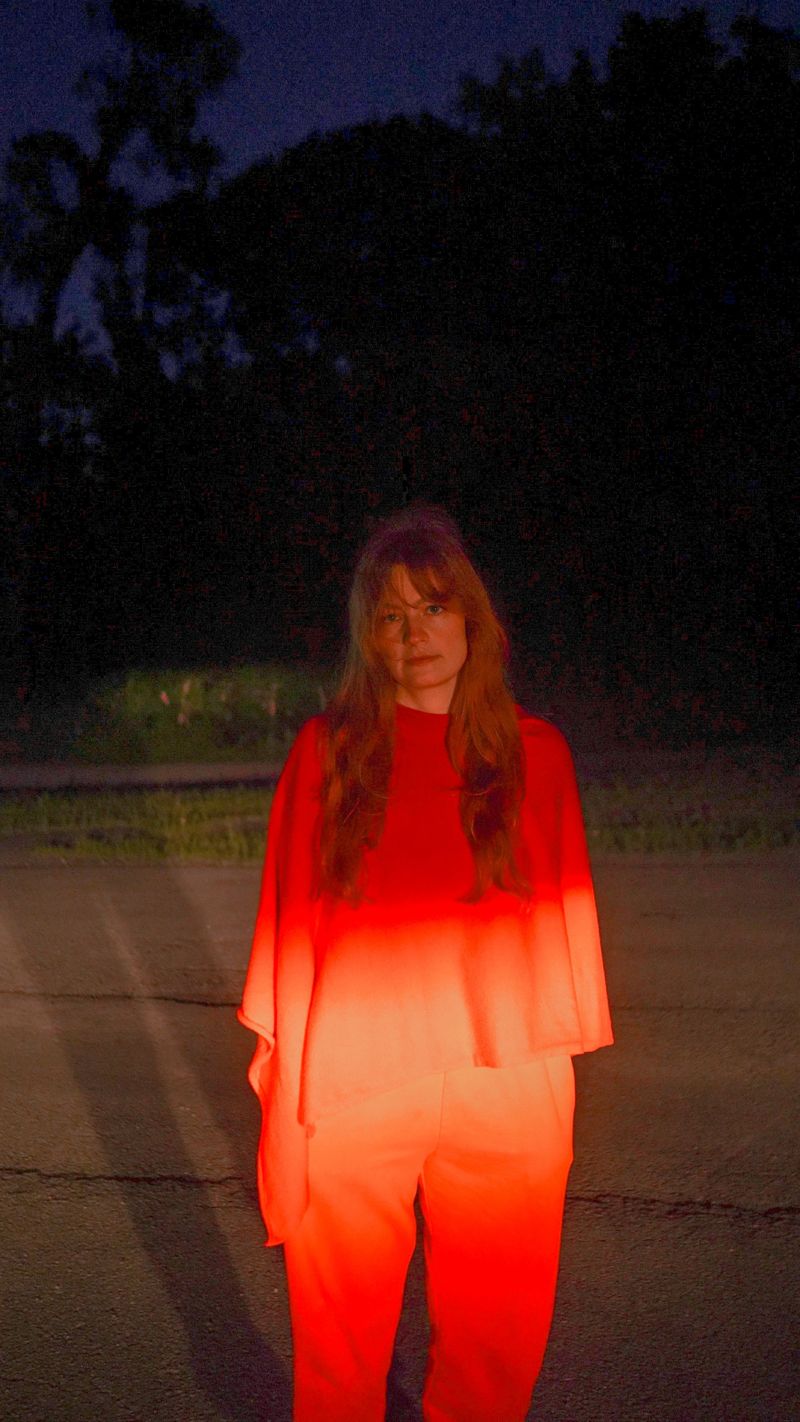 Lit by a red glow on a road at night